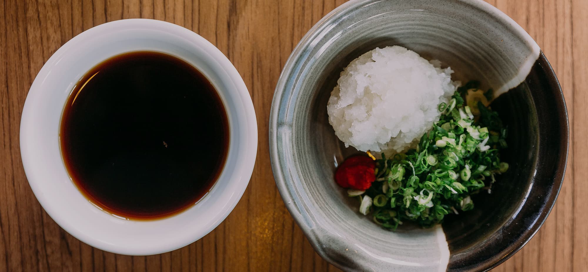 Image of a sauce in a bowl next to a serving of boiled rice